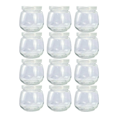 Set of clear glass 4 oz jars with white lids on a white background