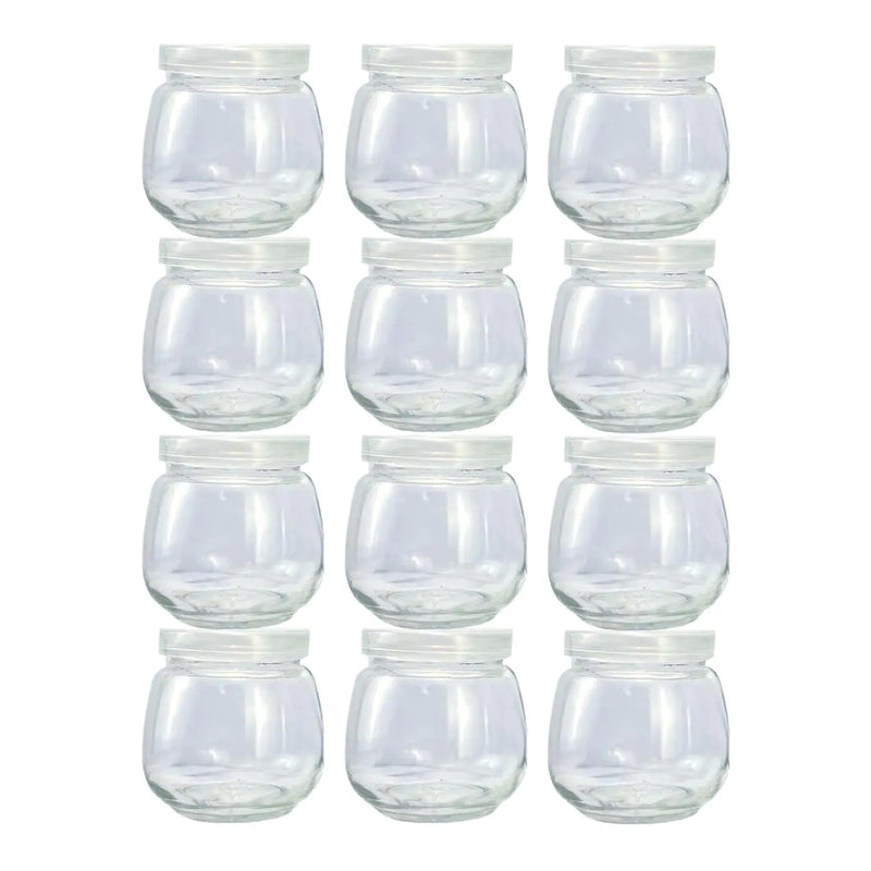 Set of clear glass 4 oz jars with white lids on a white background