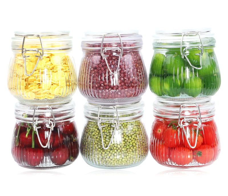 Set of six glass jars with metal clips, each containing different colored vegetables on a white background.
