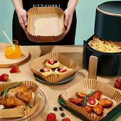 Square parchment paper liners  with food on a wooden table, including a person holding a stack of containers. and an open airfryer filled with french fries on top of a liner