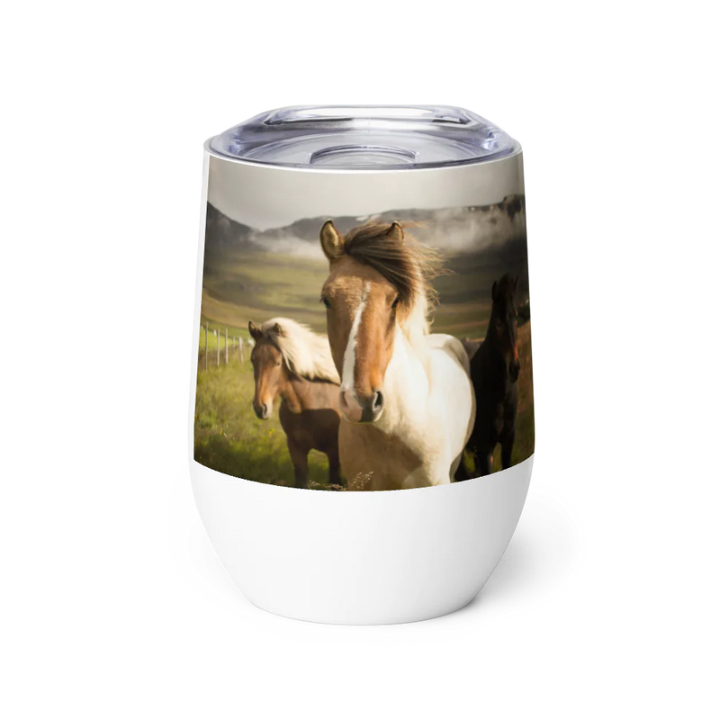 Tumbler with a design of three horses in a field on a white background