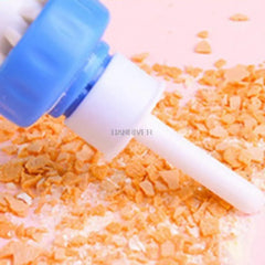 Person demonstrating using a white and blue tool ear cleaning suction device by sucking up cracker crumbs