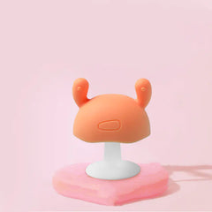 Cute silicone baby teether on a beige background